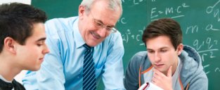 Teacher helping two students on Foundation Degree course