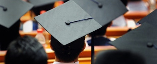 Graduate students at graduation ceremony wearing caps